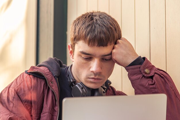 Un estudiante estudia usando una computadora portátil un estudiante masculino estudiando en línea