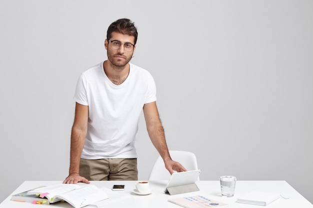 Foto gratuita el estudiante europeo trabaja en el trabajo del curso, busca información en libros o en internet