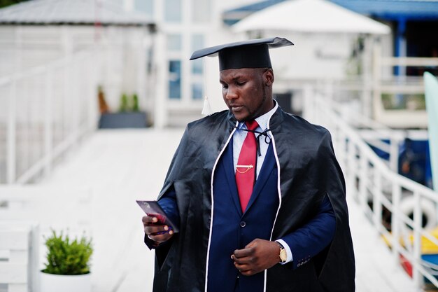 Estudiante exitoso feliz afroamericano en el sombrero de graduación