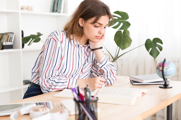 Foto gratuita estudiante femenina ocupada con la tarea