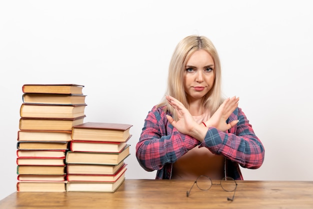 estudiante femenina sentada con libros en blanco