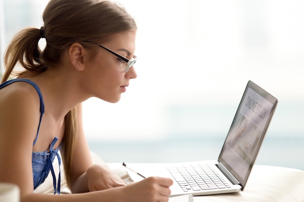 Foto gratuita estudiante femenino que estudia en línea con el ordenador portátil