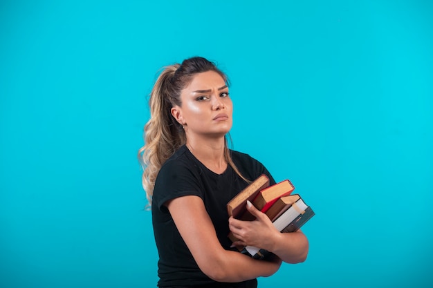 Estudiante con una gran cantidad de libros.