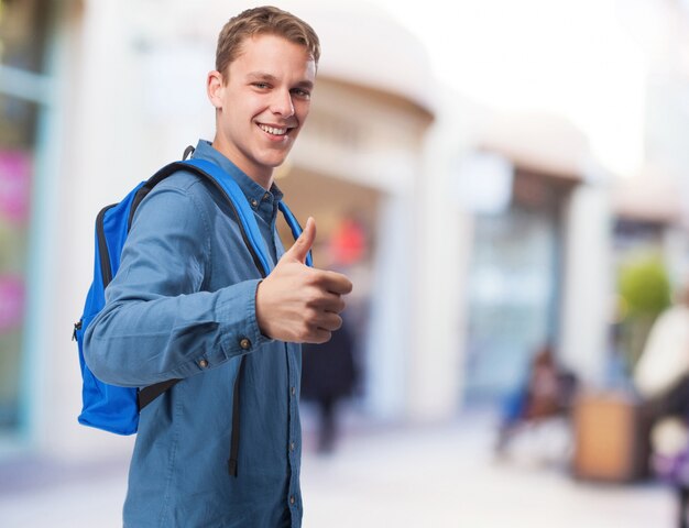 Estudiante del hombre con mochila haciendo el signo bien