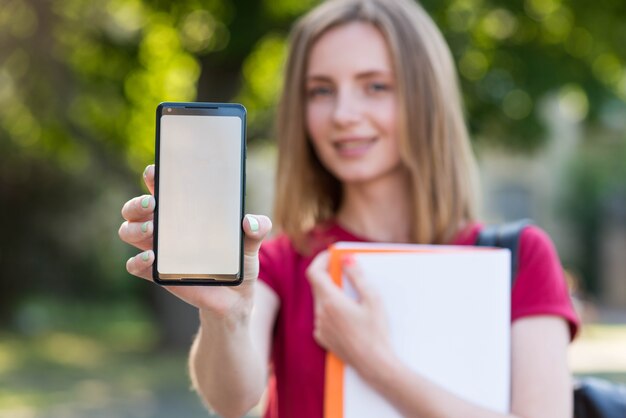 Estudiante joven enseñando plantilla de smartphone