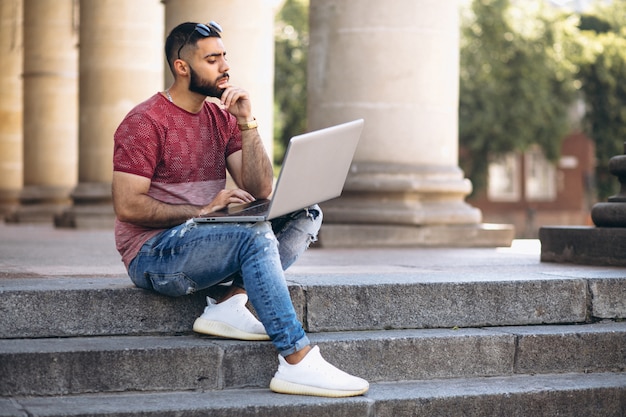 Estudiante con laptop por la universidad