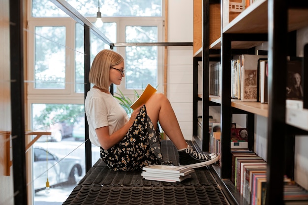 Foto gratuita estudiante leyendo un libro en la biblioteca.