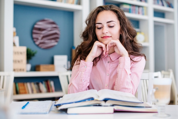 Estudiante leyendo libros en la biblioteca