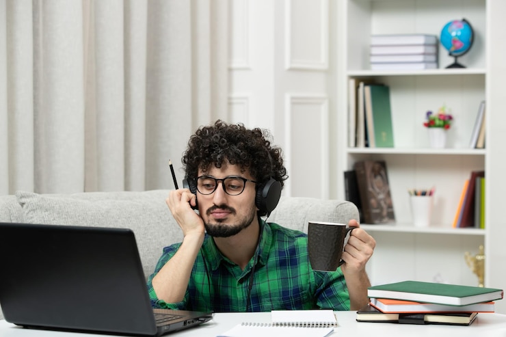 Foto gratuito estudiante en línea lindo joven estudiando en computadora con gafas en camisa verde pensando cansado