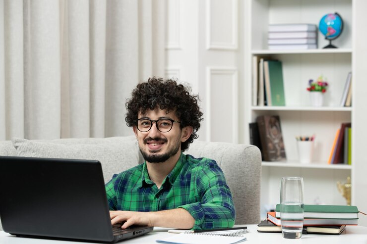 Foto gratuito estudiante en línea lindo joven estudiando en computadora con gafas en camisa verde