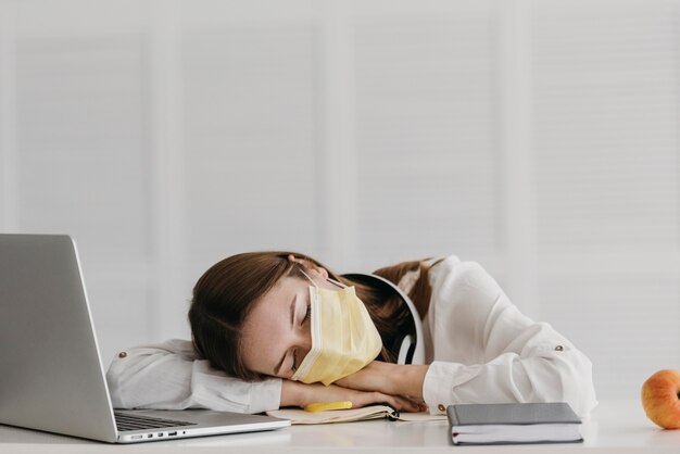 Estudiante con máscara médica y durmiendo