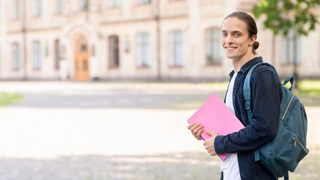 Estudiante masculino con estilo feliz de volver a la universidad