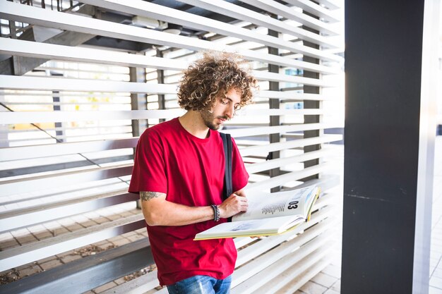 Foto gratuita estudiante masculino girando páginas de libros de texto