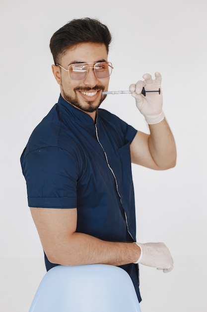 Estudiante de medicina internacional. Hombre con uniforme azul. Doctor con jeringa.