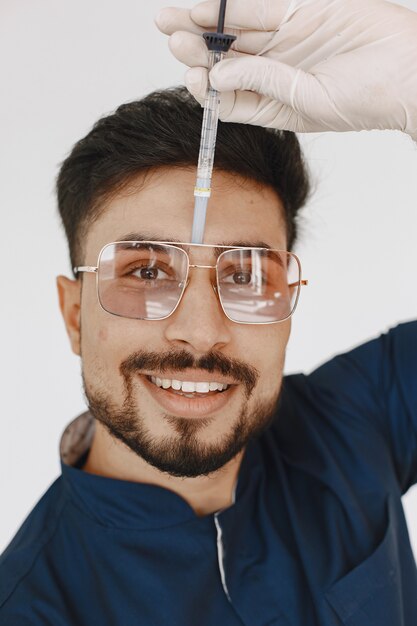 Estudiante de medicina internacional. Hombre con uniforme azul. Doctor con jeringa.