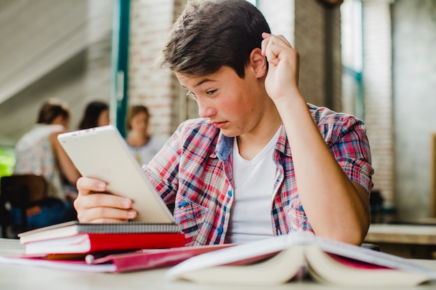 Foto gratuita estudiante mirando con perplejidad a la tableta