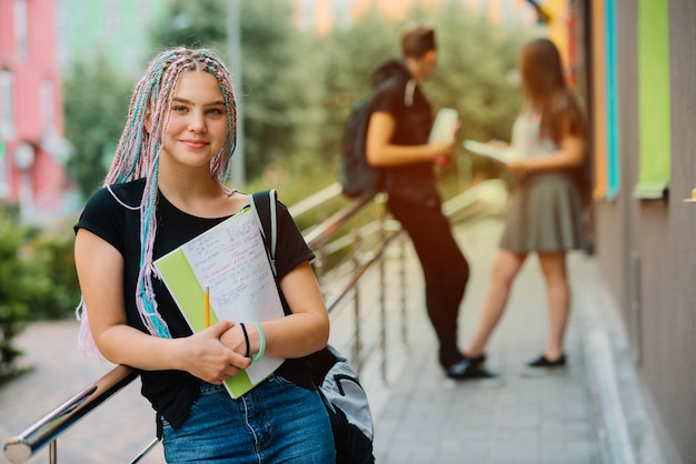 Estudiante de moda con bloc de notas en el porche