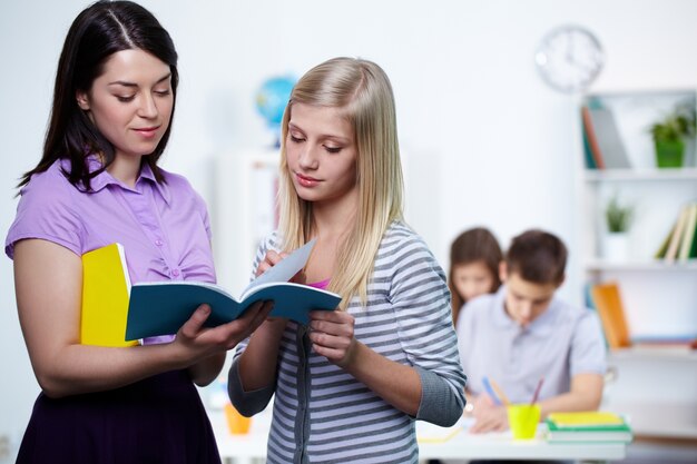 Estudiante mostrando sus deberes a la profesora