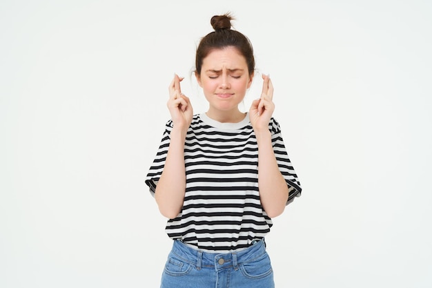 Foto gratuita una estudiante nerviosa cruza los dedos para la buena suerte haciendo deseos con la esperanza de algo anticipado