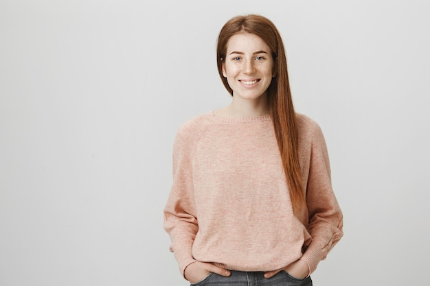 Estudiante pelirroja atractiva sonriendo ampliamente