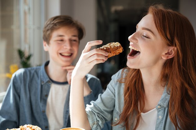 Estudiante pelirroja comiendo postre