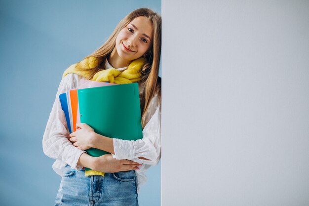 Estudiante de pie con carpetas coloridas