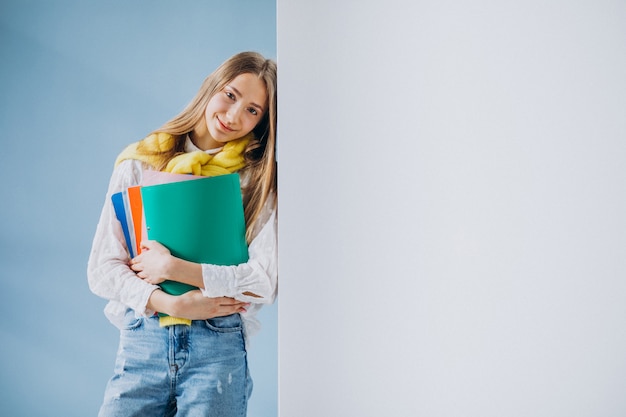 Estudiante de pie con carpetas coloridas