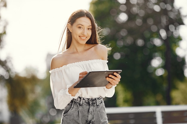 Foto gratuita estudiante de pie en una ciudad con una tableta