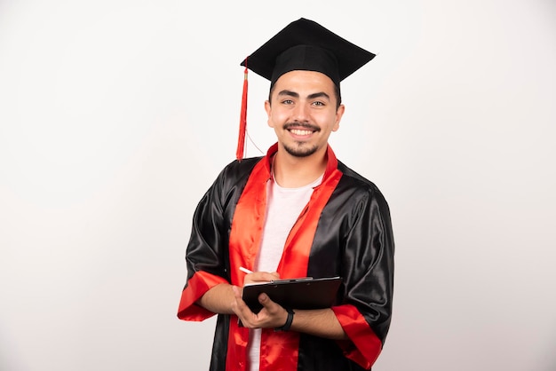 Estudiante de posgrado positivo con diploma mirando a cámara en blanco.