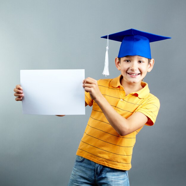 Estudiante de primaria feliz jugando con un letrero en blanco