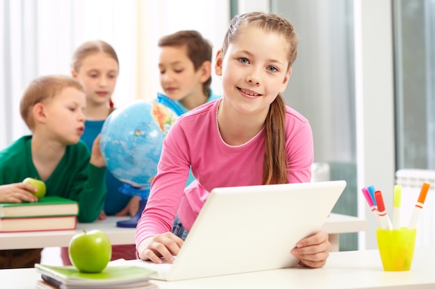 Estudiante de primaria con el ordenador en clase