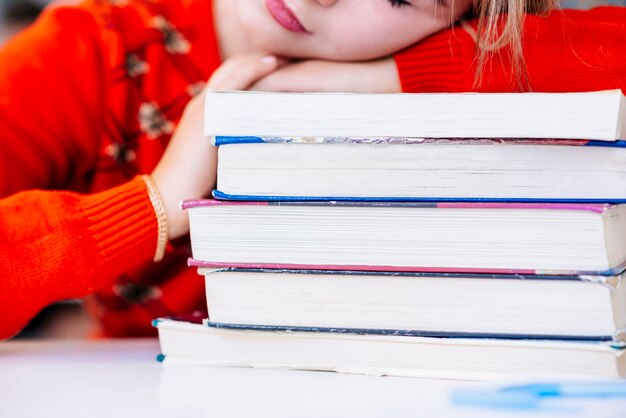 Foto gratuita estudiante que pone en libros en la mesa