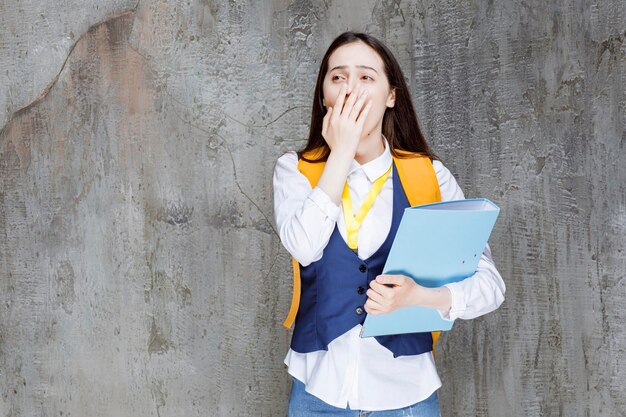 Estudiante de secundaria con mochila amarilla sintiéndose cansado. foto de alta calidad