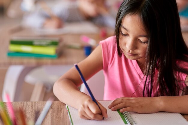 Foto gratuita estudiante sentado en el escritorio durante la lección