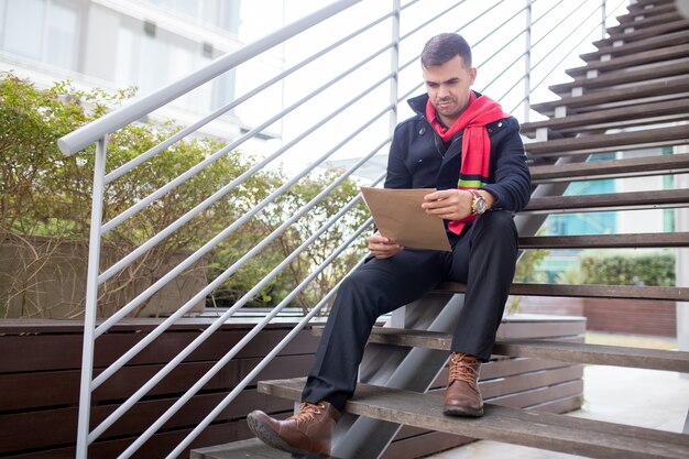 Estudiante serio o hombre de negocios que lee el papel