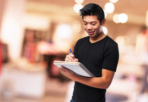 Foto gratuita estudiante sonriendo mientras hace sus deberes