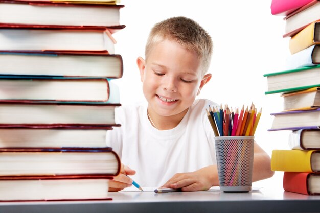 Estudiante sonriente dibujando con un lápiz de color azul