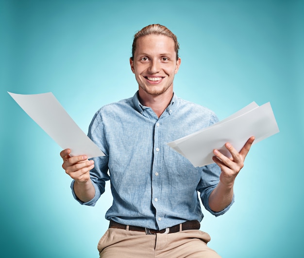 Foto gratuita estudiante sonriente inteligente con gran idea sosteniendo hojas de papel