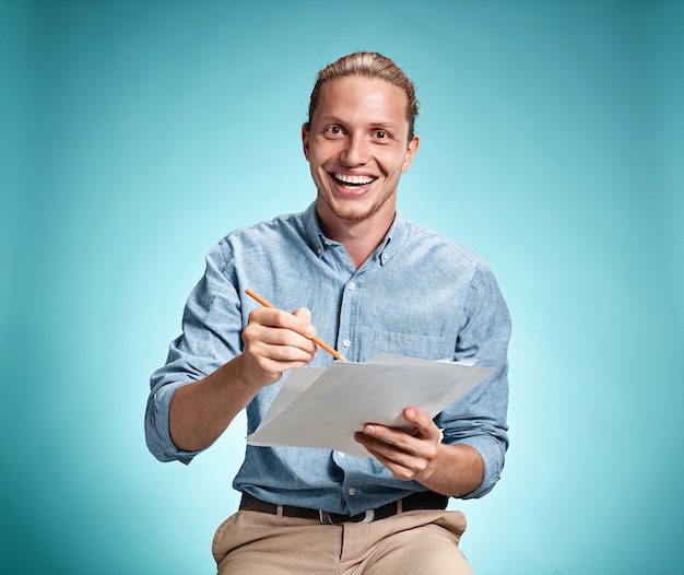 Foto gratuita estudiante sonriente inteligente con gran idea sosteniendo hojas de papel