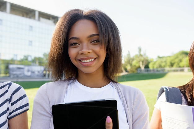 Estudiante sonriente mujer africana de pie al aire libre