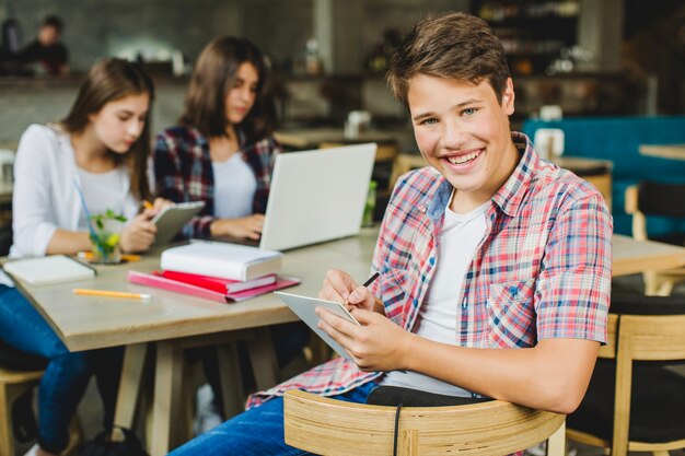 Foto gratuita estudiante con la tabla que presenta en café