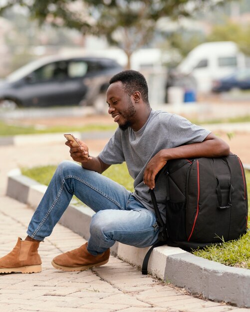 Estudiante de tiro completo sentado al aire libre