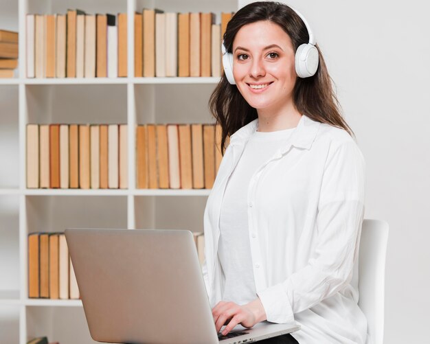 Estudiante de tiro medio en un concepto de e-learning de la biblioteca