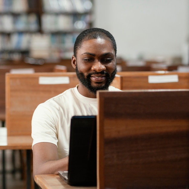 Foto gratuita estudiante de tiro medio trabajando con laptop