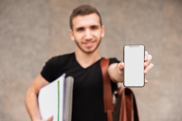 Estudiante universitario borroso mostrando su teléfono