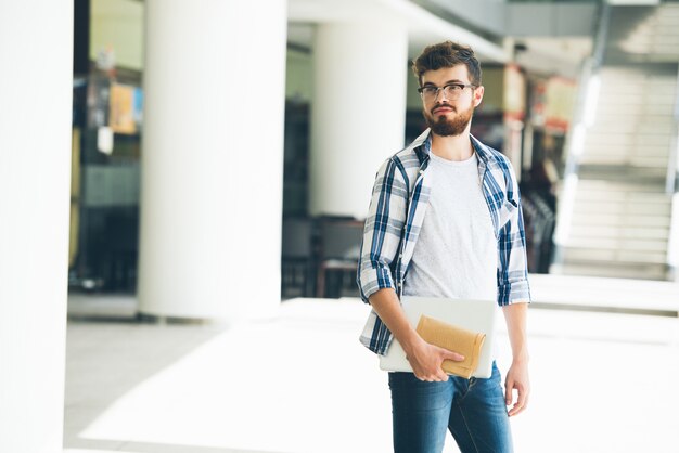 Estudiante universitario esperando a su amigo en el hall de la universidad