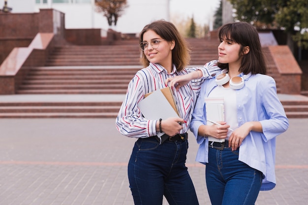 Foto gratuita estudiantes adolescentes en camisas ligeras de pie con libros.