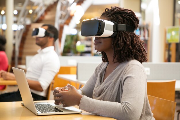 Estudiantes adultos que usan simuladores de realidad virtual para trabajar en proyectos