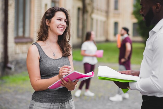 Estudiantes, afuera, sonriente, tenencia, cuadernos