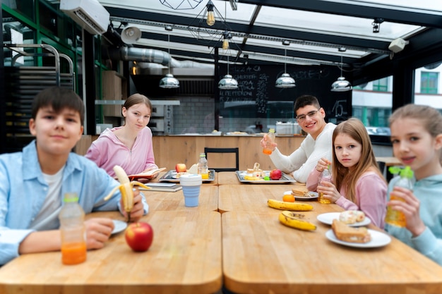 Foto gratuita estudiantes almorzando en la cantina